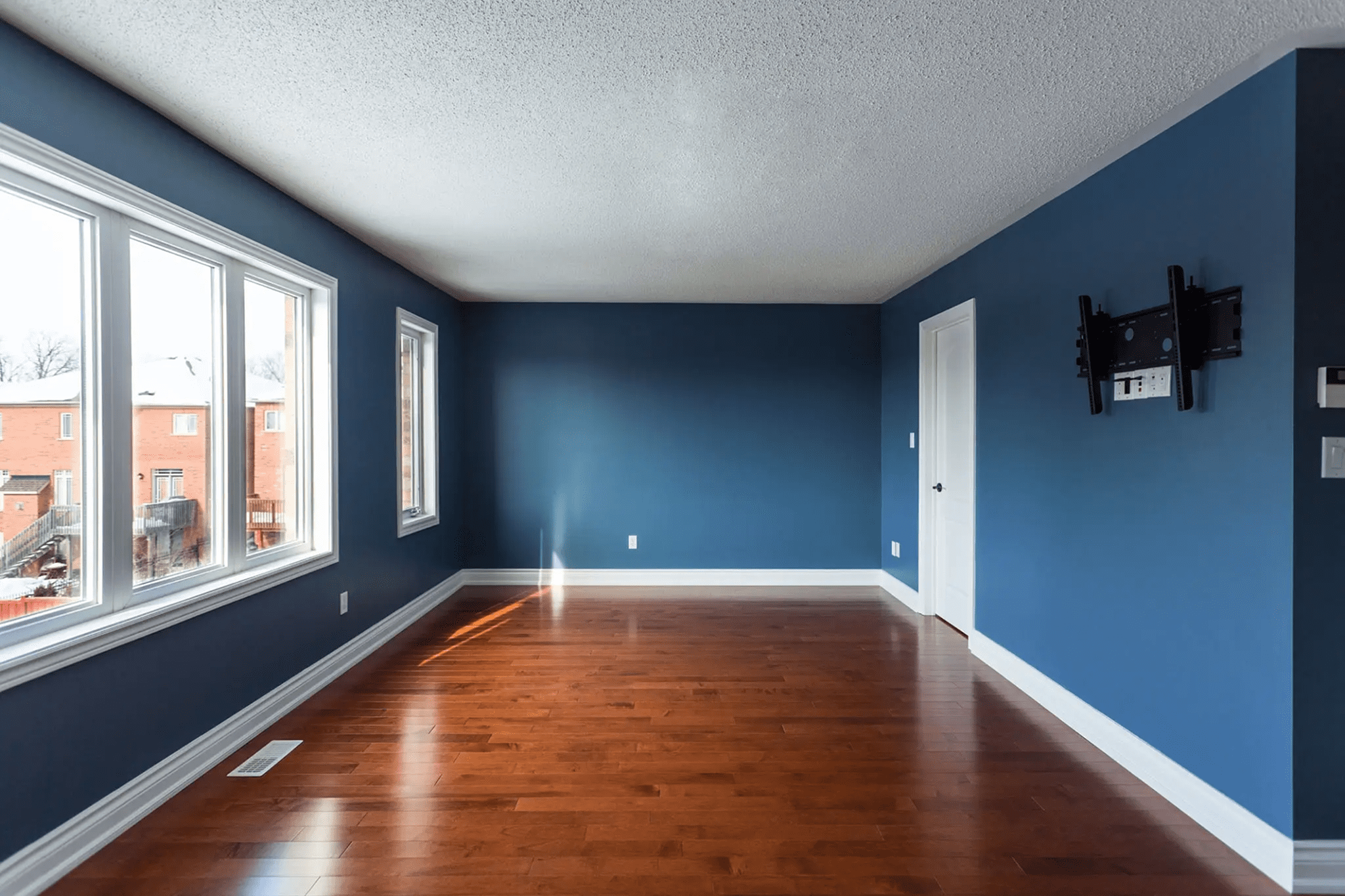 Sunlit empty room with blue accent wall